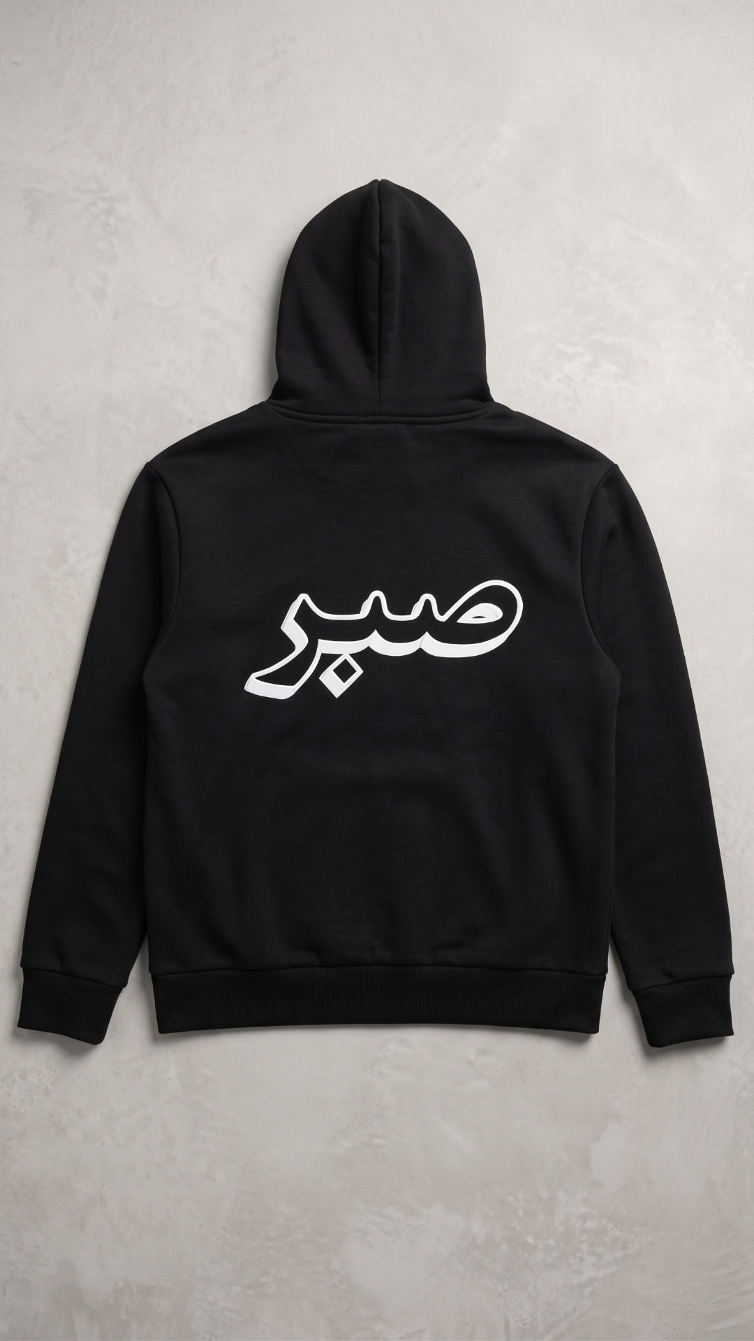 Back of the black Dilkash hoodie showing the full cream Sabr embroidery